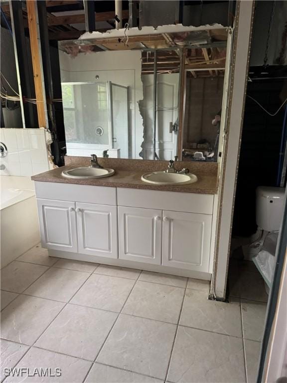 full bathroom with tile patterned floors, a bathing tub, double vanity, and a sink