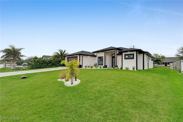 view of front of house featuring an attached garage, concrete driveway, and a front yard