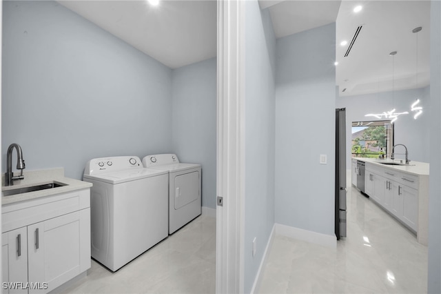 washroom featuring a sink, baseboards, laundry area, and washing machine and clothes dryer