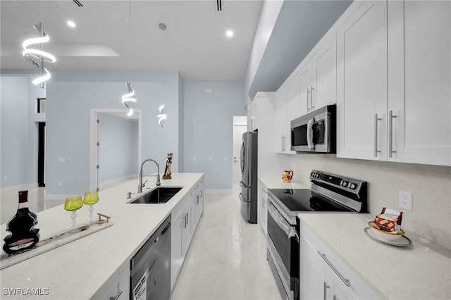 kitchen featuring a sink, stainless steel appliances, light countertops, and white cabinetry