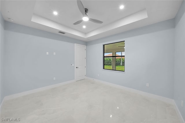 unfurnished room featuring baseboards, visible vents, a tray ceiling, recessed lighting, and ceiling fan