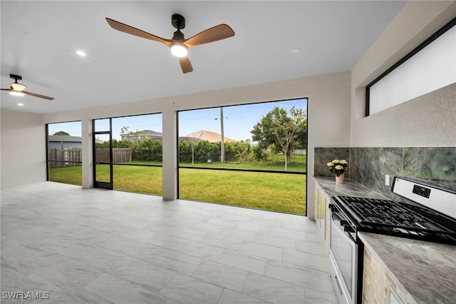 unfurnished sunroom featuring plenty of natural light and a ceiling fan