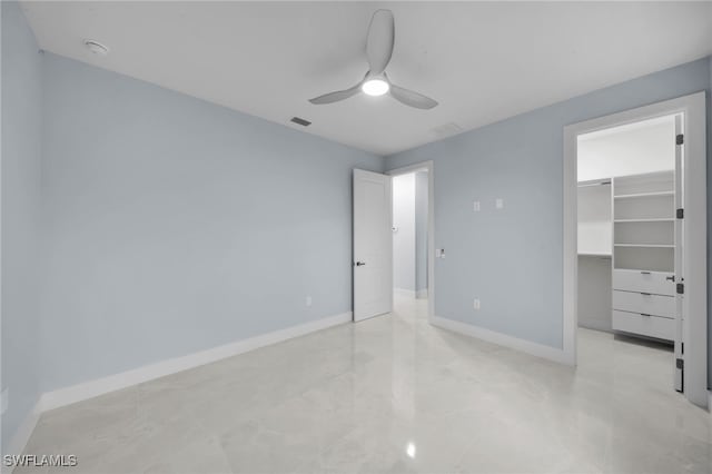 unfurnished bedroom with visible vents, baseboards, ceiling fan, a spacious closet, and a closet