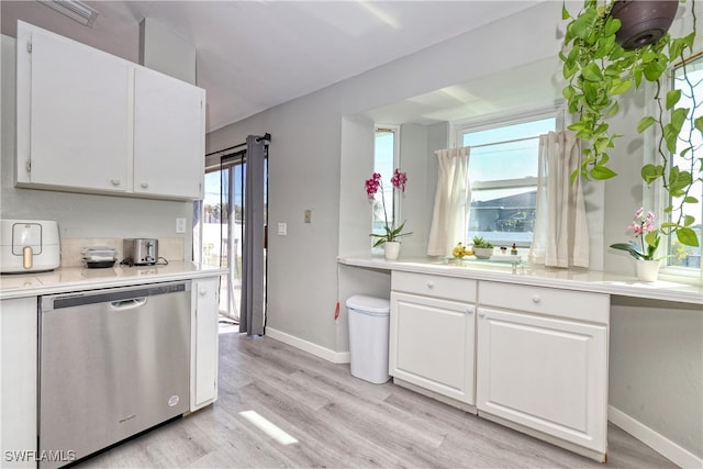 kitchen featuring light wood-style flooring, white cabinetry, light countertops, and stainless steel dishwasher