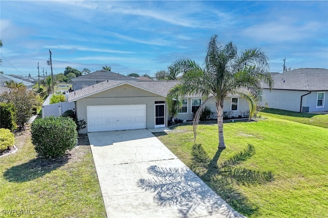 ranch-style home featuring a front lawn, fence, stucco siding, a garage, and driveway