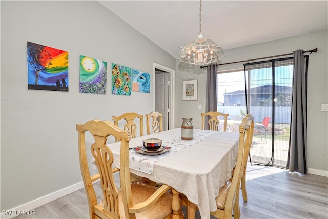 dining area featuring baseboards, an inviting chandelier, vaulted ceiling, and light wood finished floors