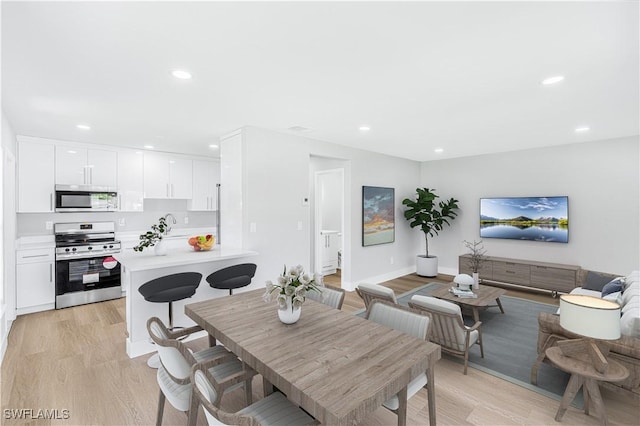 dining room with light wood-style flooring and recessed lighting