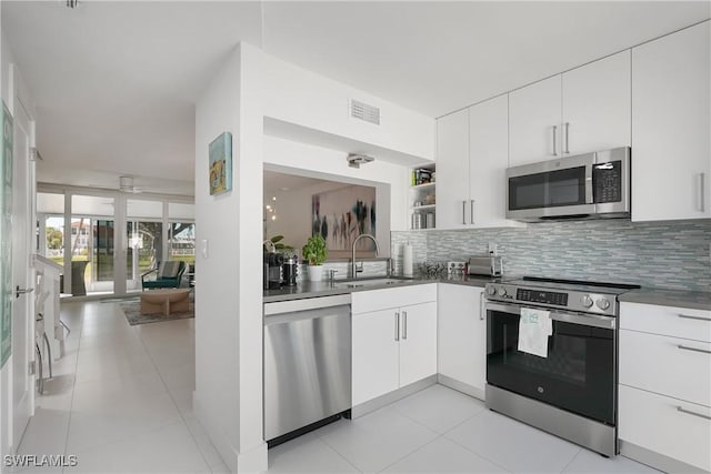 kitchen with dark countertops, tasteful backsplash, and appliances with stainless steel finishes