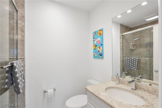 bathroom featuring vanity, toilet, recessed lighting, and tiled shower