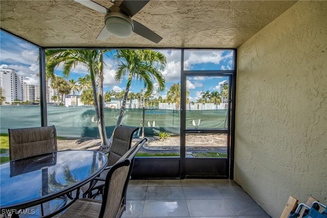 unfurnished sunroom featuring a ceiling fan