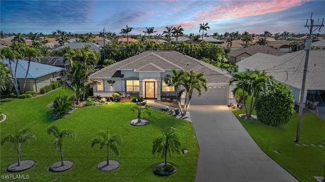 ranch-style house featuring stucco siding, concrete driveway, a front lawn, a garage, and a residential view