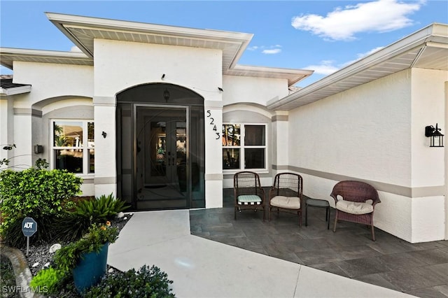 entrance to property with french doors and stucco siding