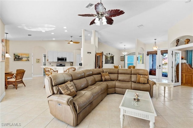 living area with arched walkways, visible vents, light tile patterned floors, and vaulted ceiling