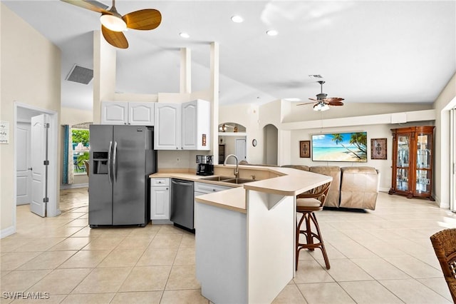 kitchen featuring light tile patterned floors, a ceiling fan, a peninsula, a sink, and stainless steel appliances