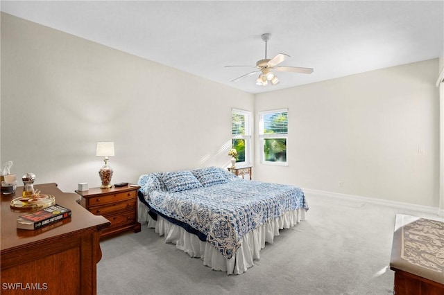 bedroom with light colored carpet, baseboards, and ceiling fan