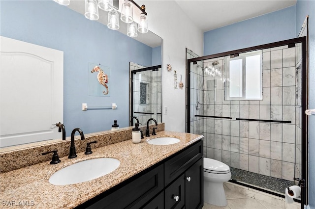 bathroom featuring double vanity, toilet, a stall shower, and a sink