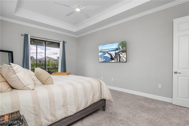 carpeted bedroom with ceiling fan, baseboards, a raised ceiling, and ornamental molding