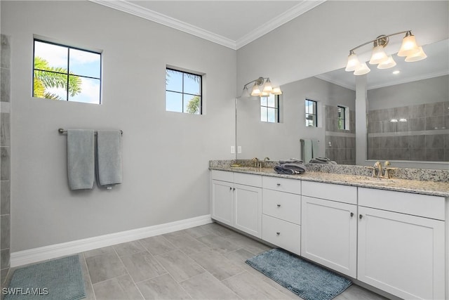 bathroom featuring ornamental molding, a walk in shower, a sink, double vanity, and baseboards