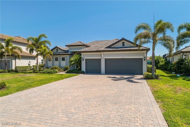 view of front of home with a garage, stucco siding, decorative driveway, and a front lawn