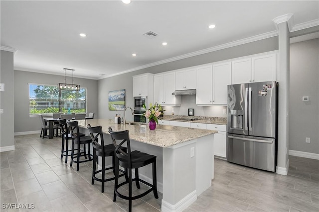 kitchen featuring a kitchen island with sink, ornamental molding, a kitchen breakfast bar, stainless steel appliances, and white cabinets