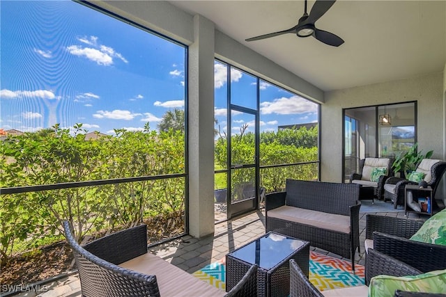 sunroom / solarium featuring a ceiling fan