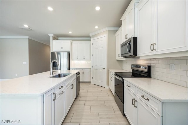 kitchen featuring backsplash, ornamental molding, appliances with stainless steel finishes, white cabinetry, and a sink