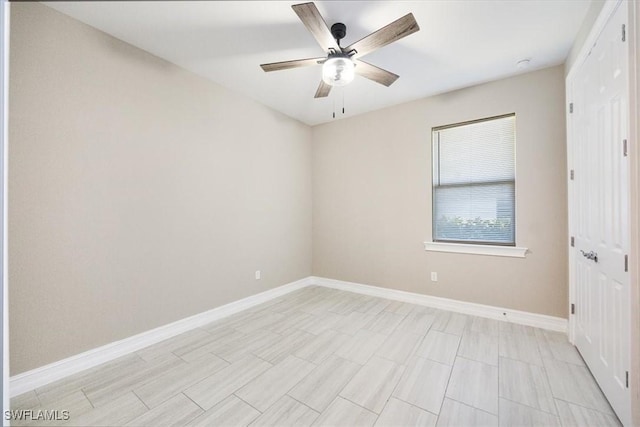 unfurnished room with a ceiling fan and baseboards