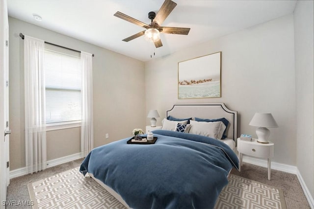 carpeted bedroom with a ceiling fan and baseboards