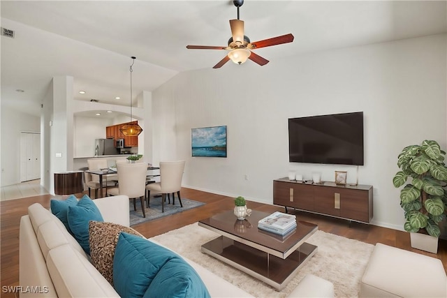 living area with baseboards, lofted ceiling, recessed lighting, wood finished floors, and a ceiling fan