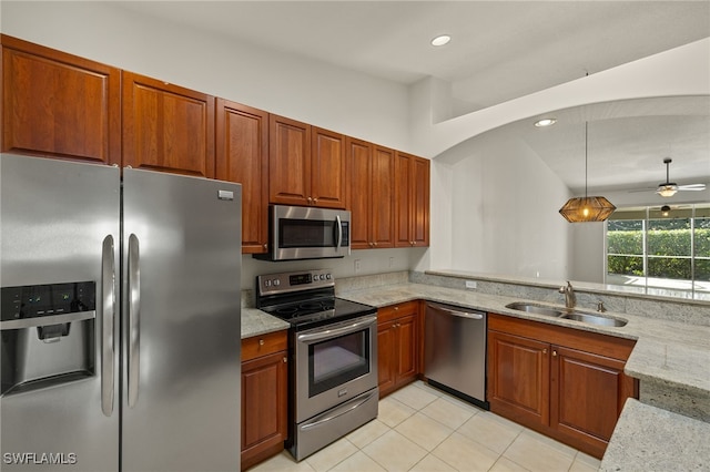 kitchen with light stone countertops, recessed lighting, a peninsula, stainless steel appliances, and a sink