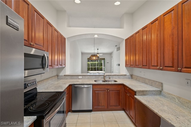 kitchen with a sink, recessed lighting, stainless steel appliances, light tile patterned floors, and light stone countertops