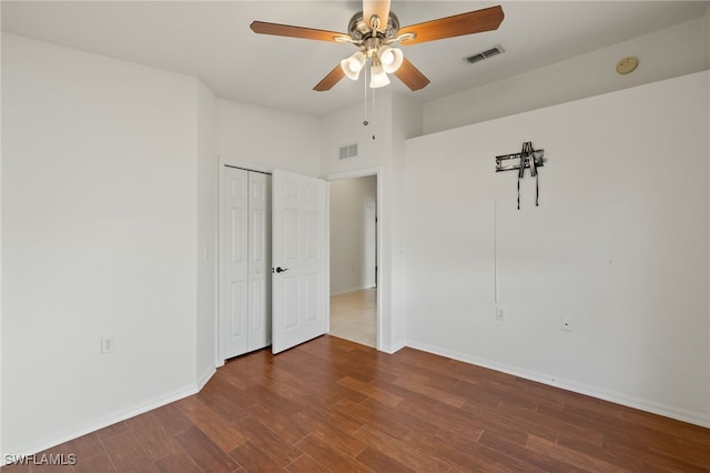 unfurnished room with ceiling fan, visible vents, baseboards, and wood finished floors