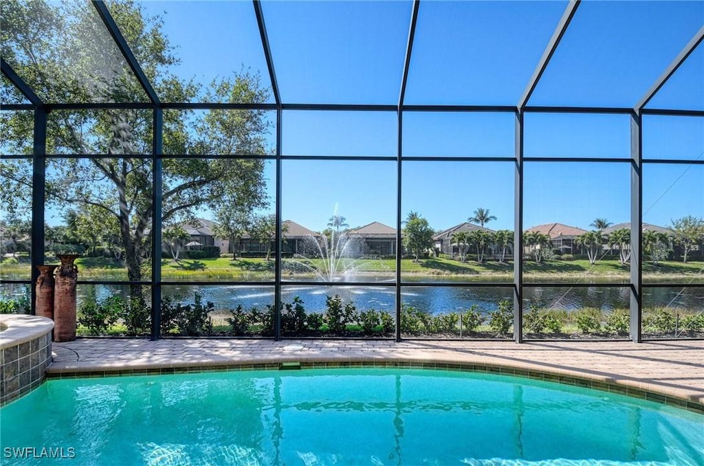 outdoor pool with glass enclosure, central air condition unit, and a water view