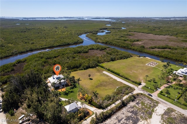 drone / aerial view with a wooded view and a water view