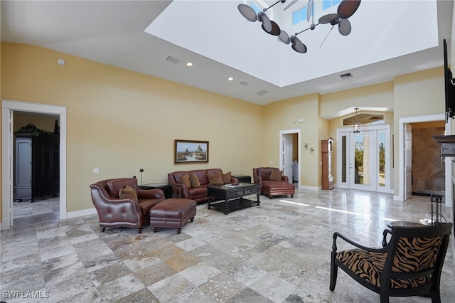 living area featuring visible vents, baseboards, a towering ceiling, and ceiling fan