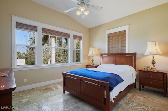 bedroom with multiple windows, baseboards, lofted ceiling, and stone finish flooring