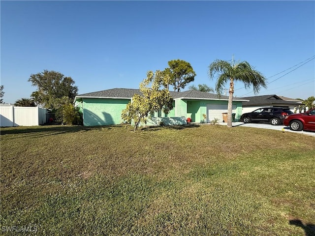 single story home featuring a garage, concrete driveway, a front yard, and fence