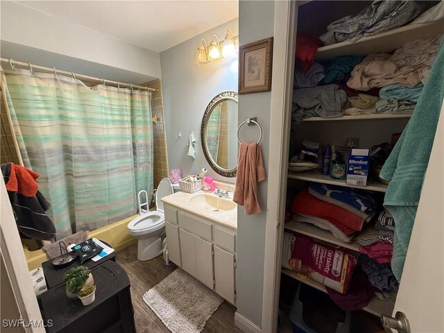 bathroom with vanity, toilet, wood finished floors, and shower / tub combo with curtain