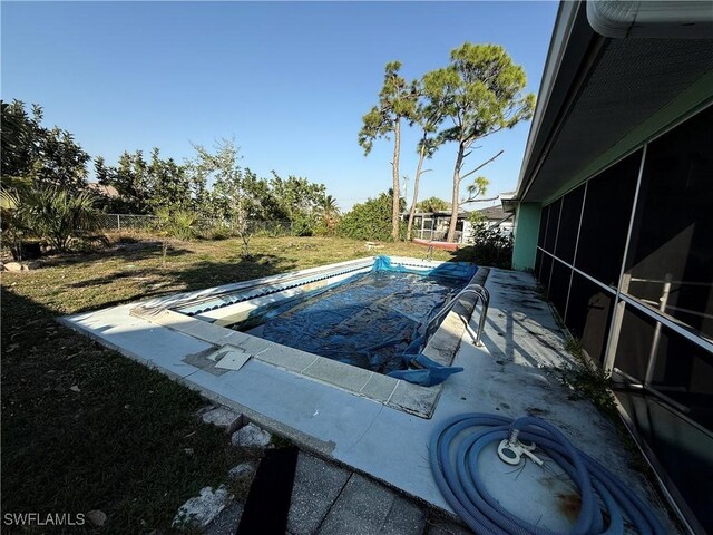 view of swimming pool with a patio and a sunroom