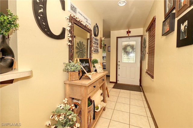 doorway to outside with light tile patterned floors and baseboards