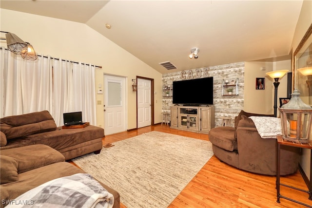 living room with visible vents, wood finished floors, and vaulted ceiling