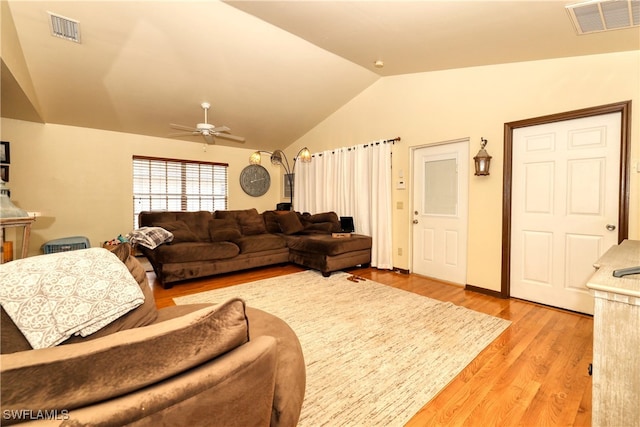 living room with vaulted ceiling, light wood-style flooring, visible vents, and ceiling fan