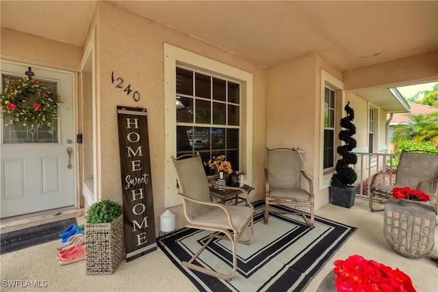 view of exterior entry featuring covered porch and stucco siding