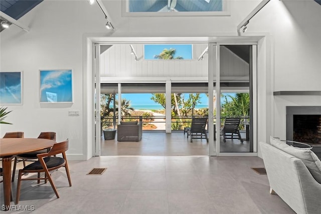 16886 Captiva Dr, Captiva, FL 33924 - interior space featuring visible vents, a high ceiling, a fireplace with raised hearth, and rail lighting