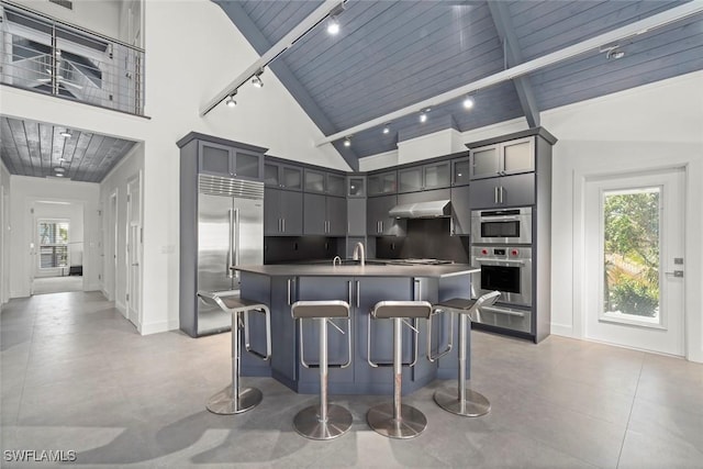 16886 Captiva Dr, Captiva, FL 33924 - kitchen with high vaulted ceiling, beamed ceiling, stainless steel appliances, under cabinet range hood, and a sink