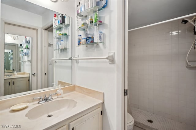 bathroom with toilet, a stall shower, and vanity