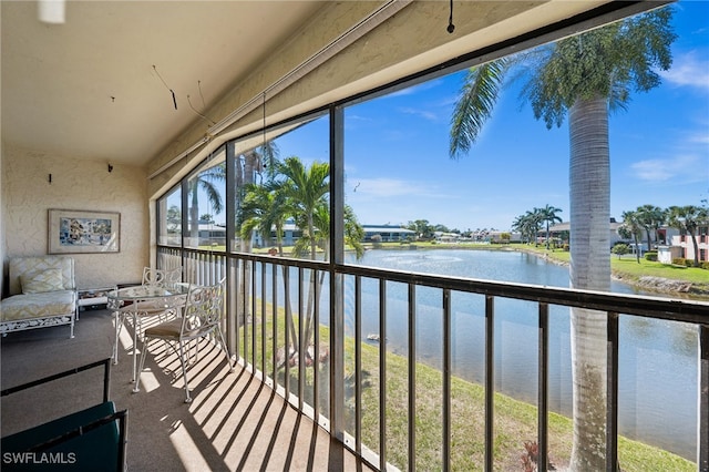 sunroom featuring a water view