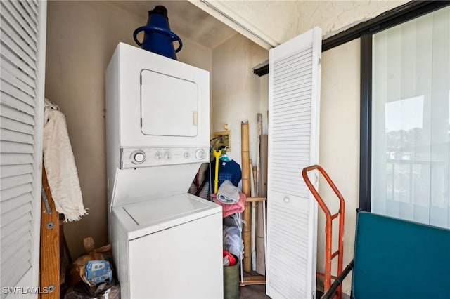 washroom featuring stacked washer and dryer and laundry area