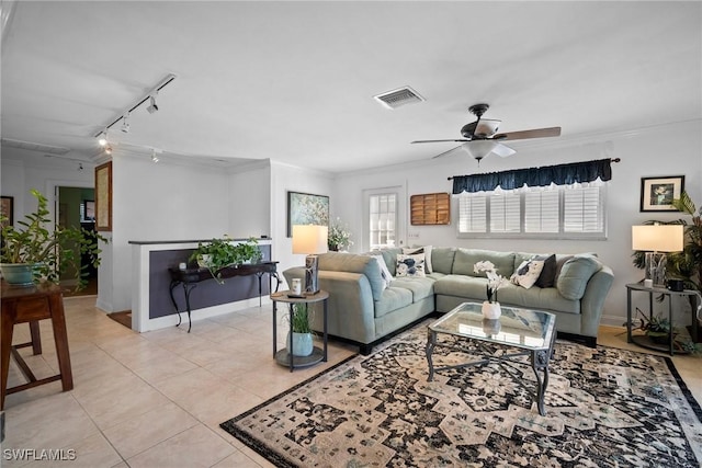 living area featuring light tile patterned flooring, visible vents, crown molding, and baseboards