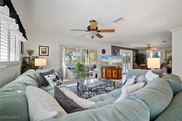 living room featuring visible vents, ceiling fan, and crown molding